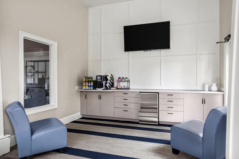 A living room with a blue chair and a white cabinet.