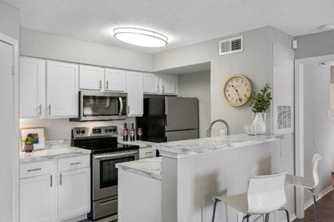 a kitchen with white cabinets and stainless steel appliances