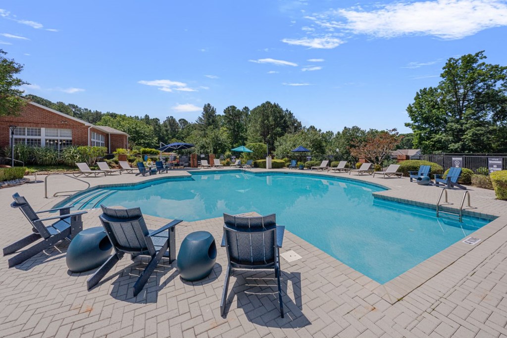 a swimming pool with chairs and chairs around it