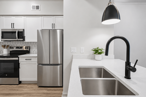A modern kitchen with a stainless steel refrigerator and a black oven.