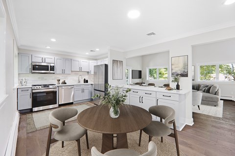 A modern kitchen with a dining table set for four.