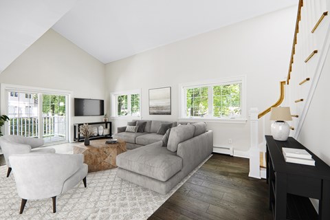 A living room with a grey couch and a white chair.