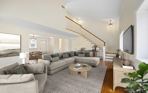 A living room with a grey couch and a wooden coffee table.