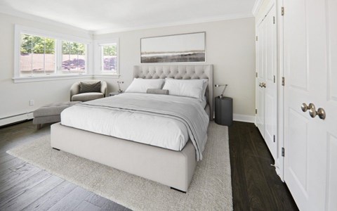 A bedroom with a large bed and a window.