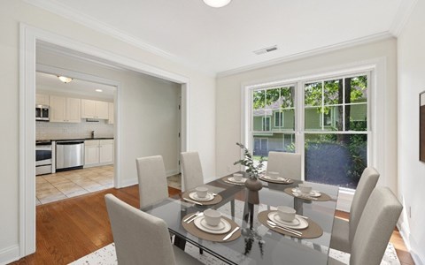 A dining room with a glass table and chairs.