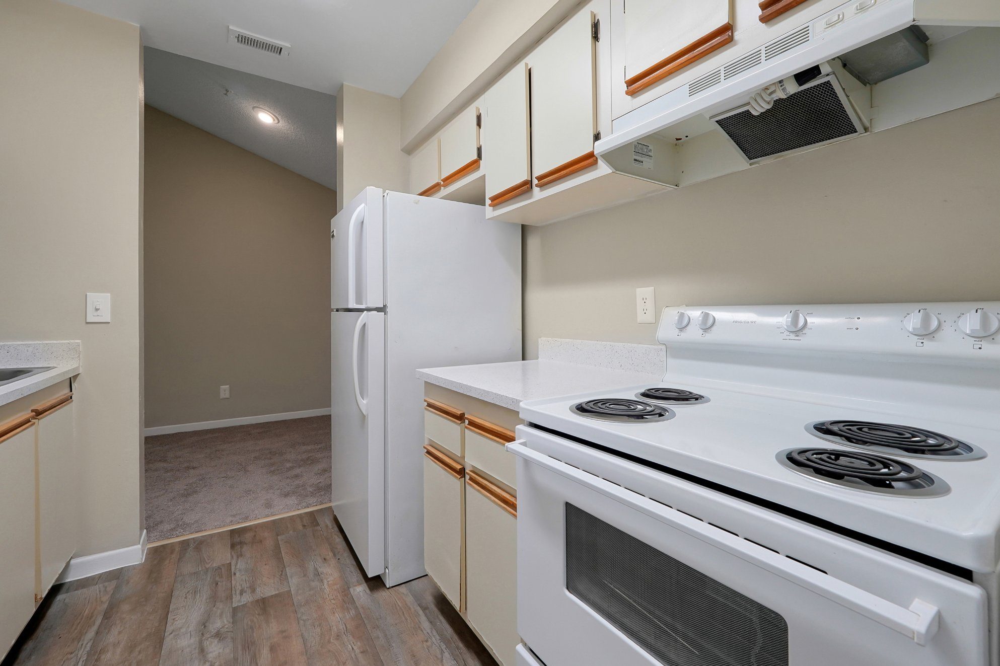 A white stove with a white refrigerator in a kitchen.