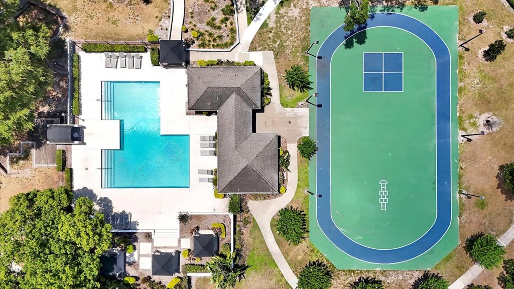 an aerial view of a tennis court and a house with a pool