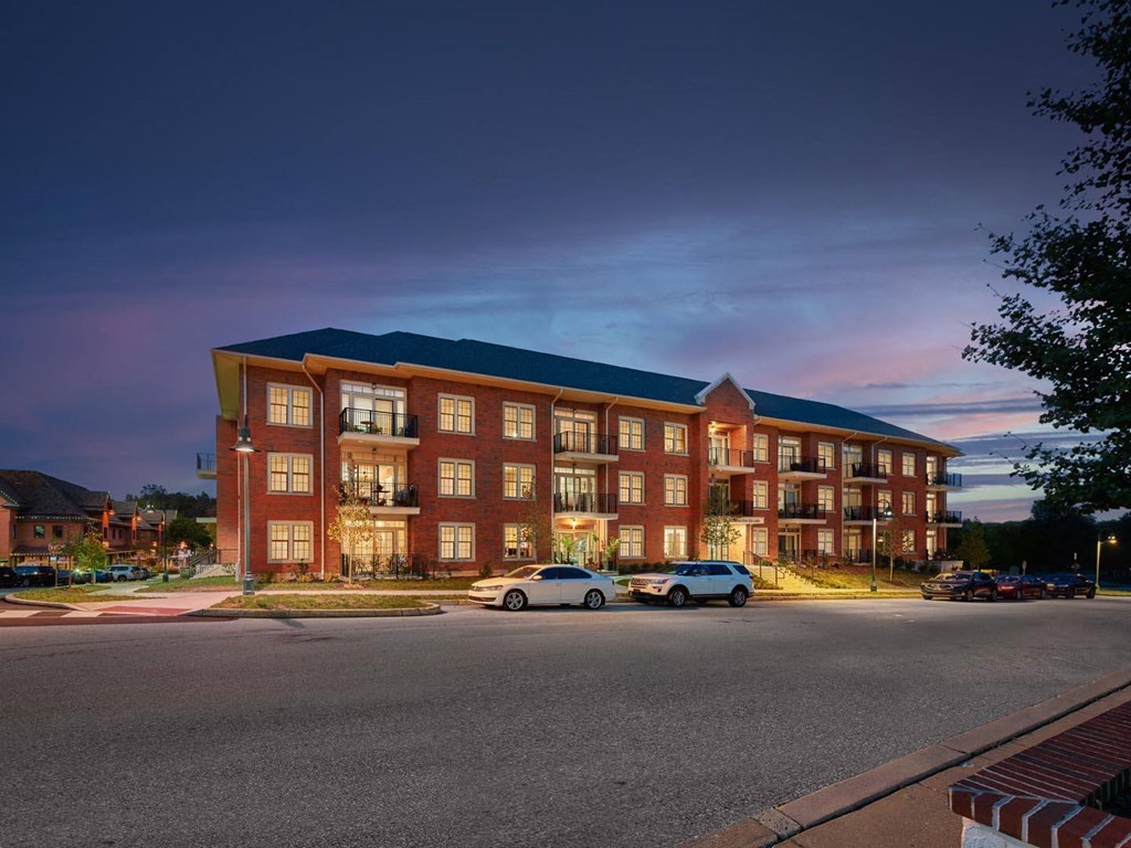 A large red brick building with a parking lot in front of it.