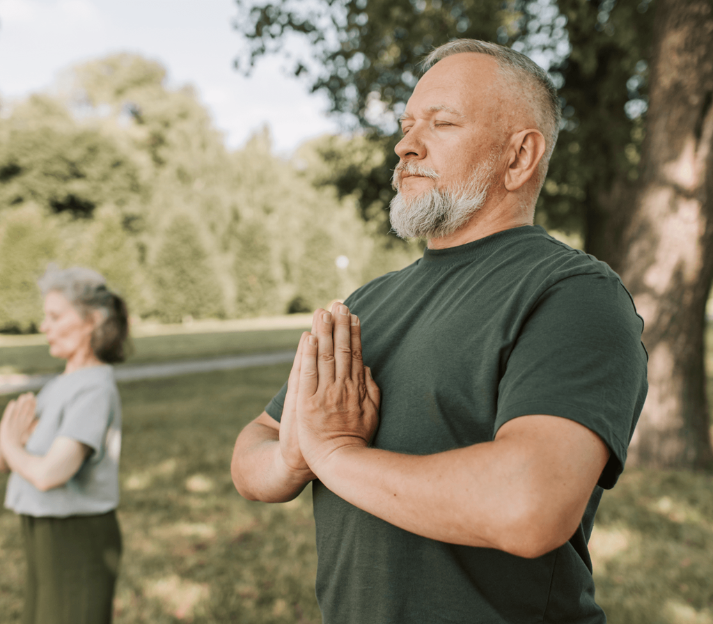 a man and a woman standing in a park with their hands together