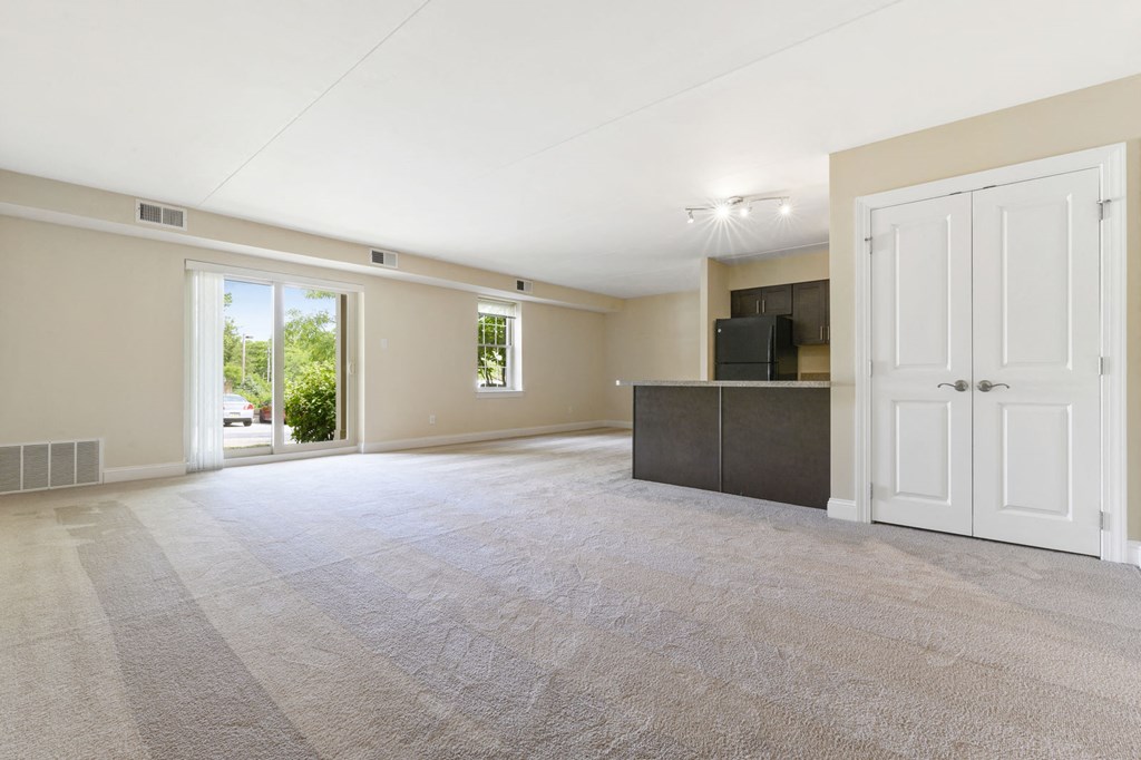 an empty living room with a door to a porch