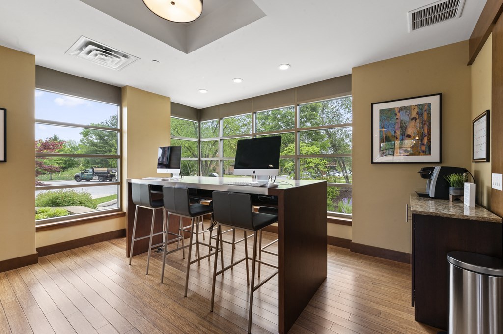 A modern kitchen with a bar stool and a television.