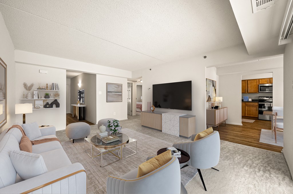 A modern living room with a white sofa, a coffee table, and a television.