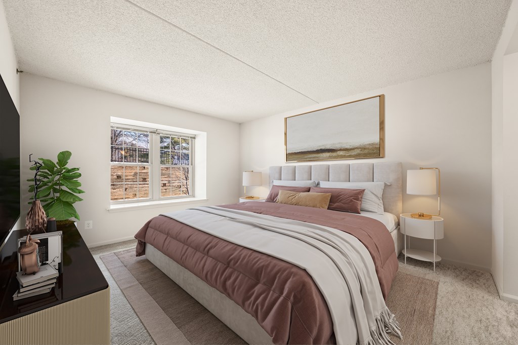 A bedroom with a large bed and a window overlooking a snowy landscape.