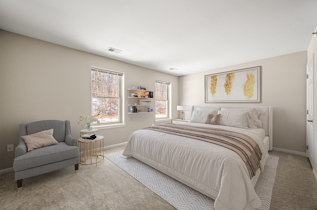 A bedroom with a bed, chair, and window.