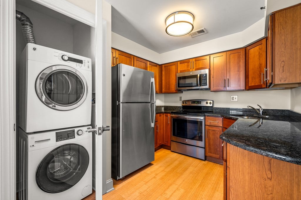 A modern kitchen with a washer and dryer built into the cabinetry.