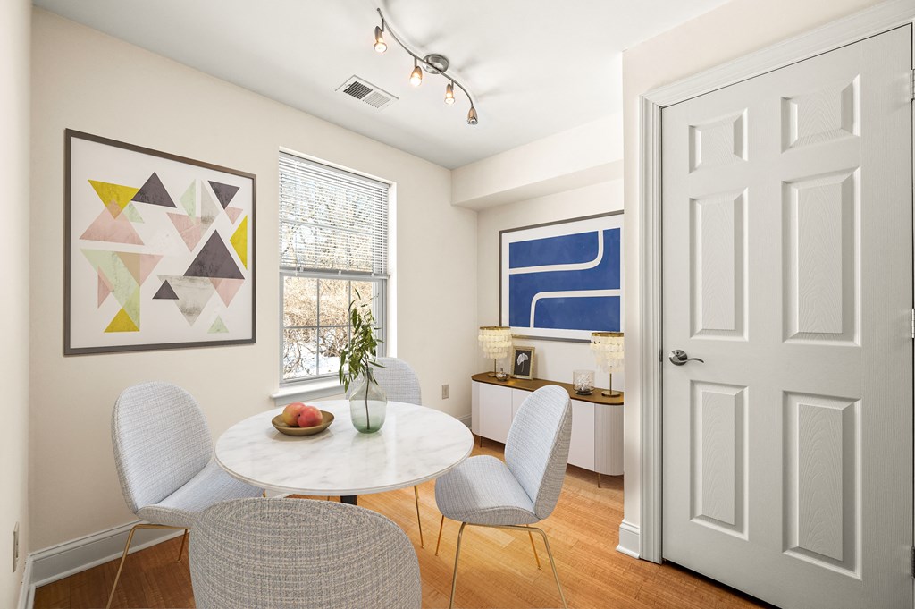 A dining room with a white table and chairs.