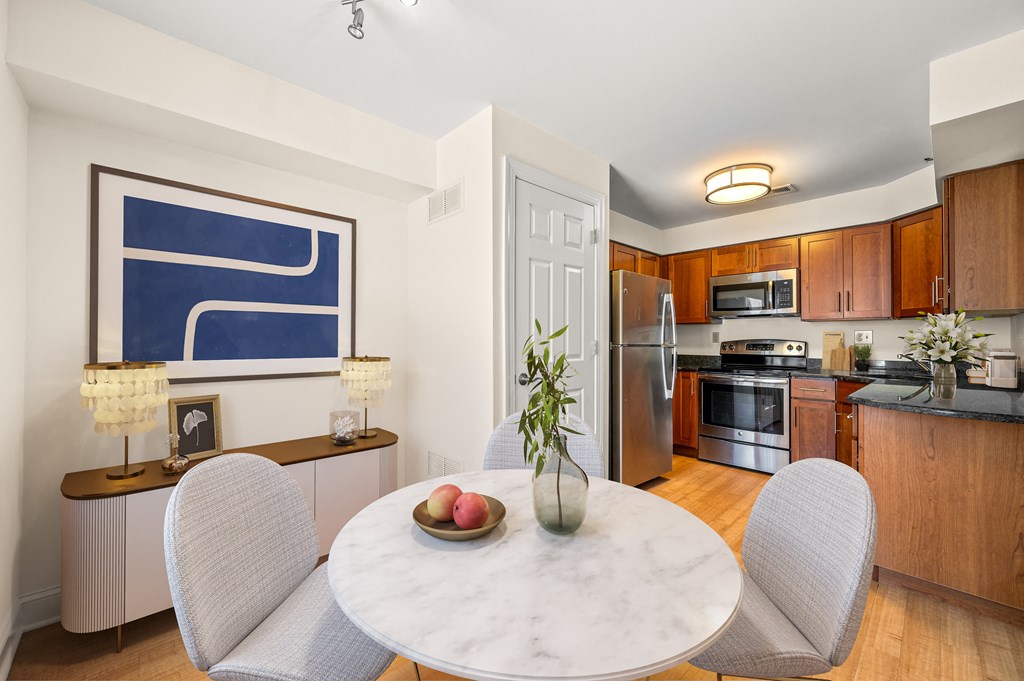 A modern kitchen with a dining table set for two.