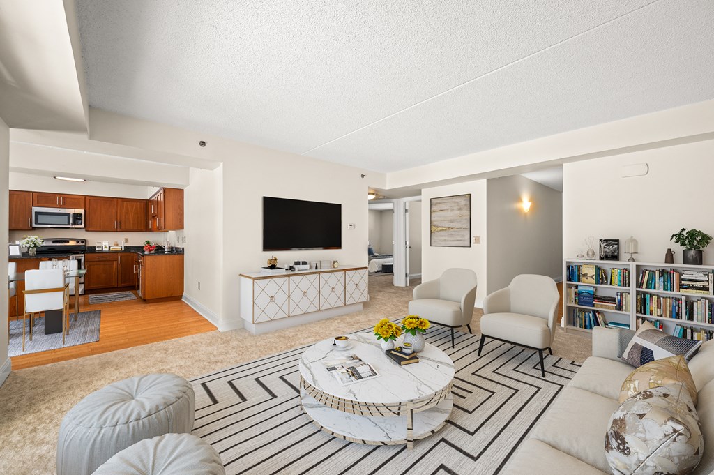 A living room with a white couch, a coffee table, and a television.