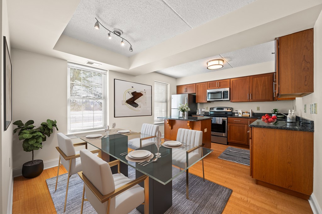 A modern kitchen with a dining table set for two.