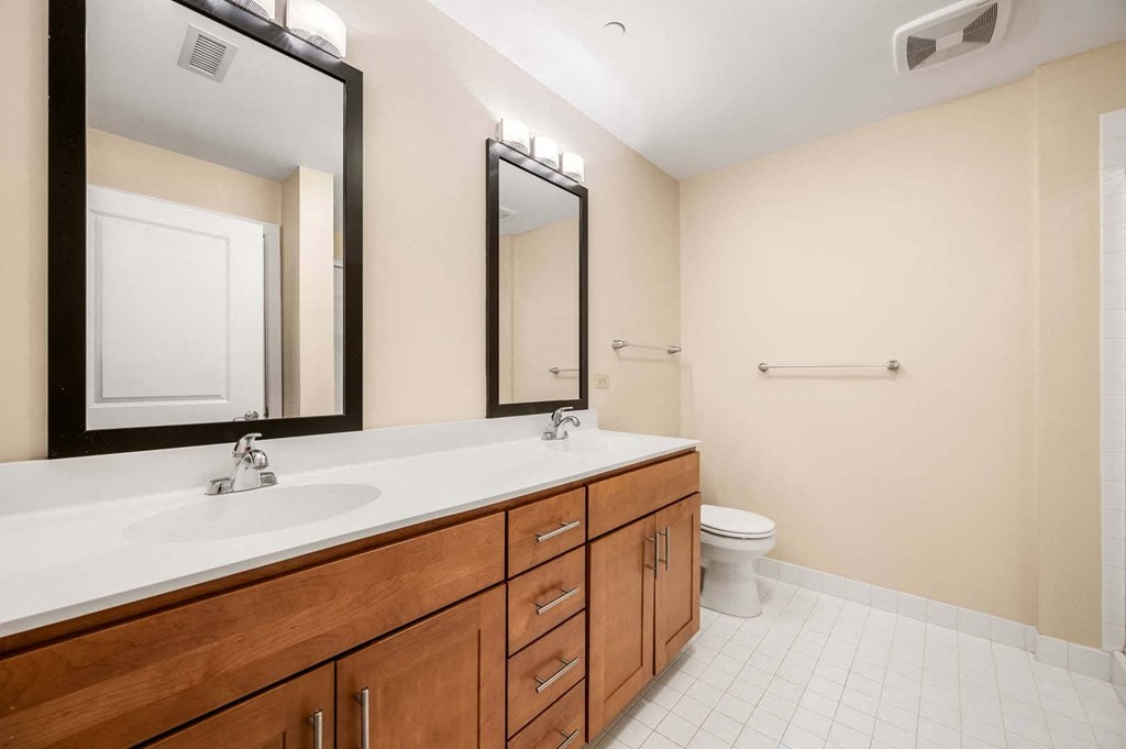 A bathroom with a toilet, sink, and mirror.