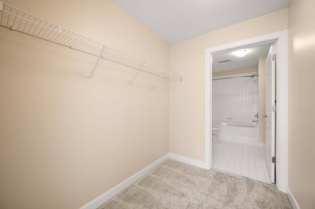 A small room with a white door leading to a bathroom.