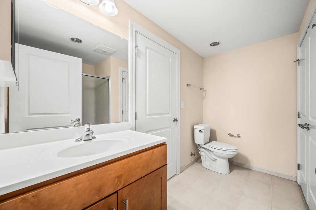 A white sink in a bathroom with a toilet in the background.