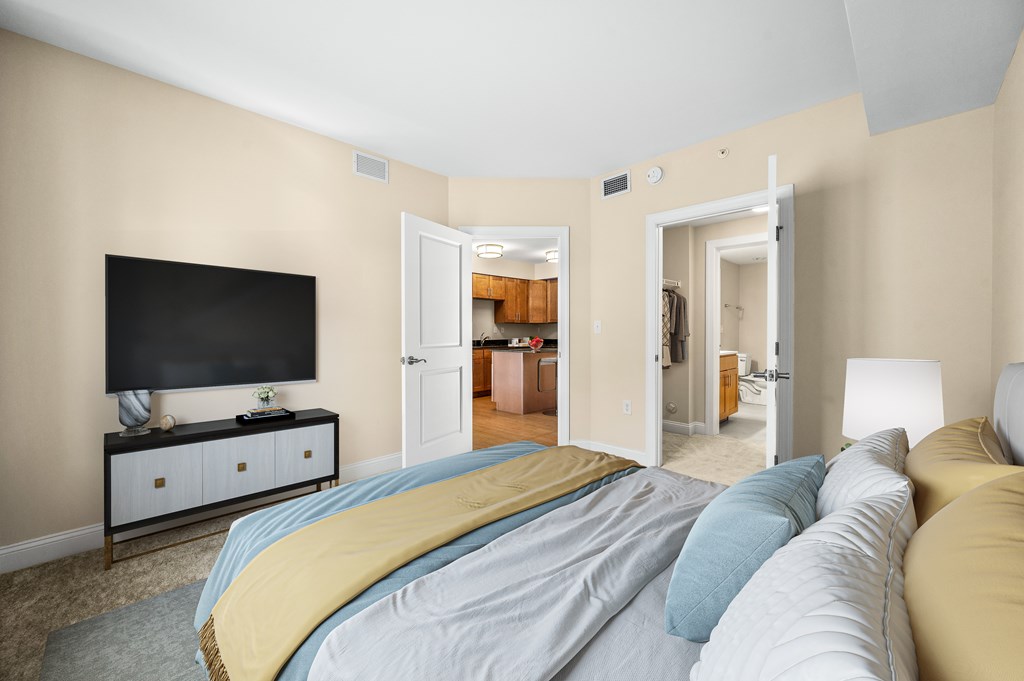 A bedroom with a bed, a television, and a cabinet.