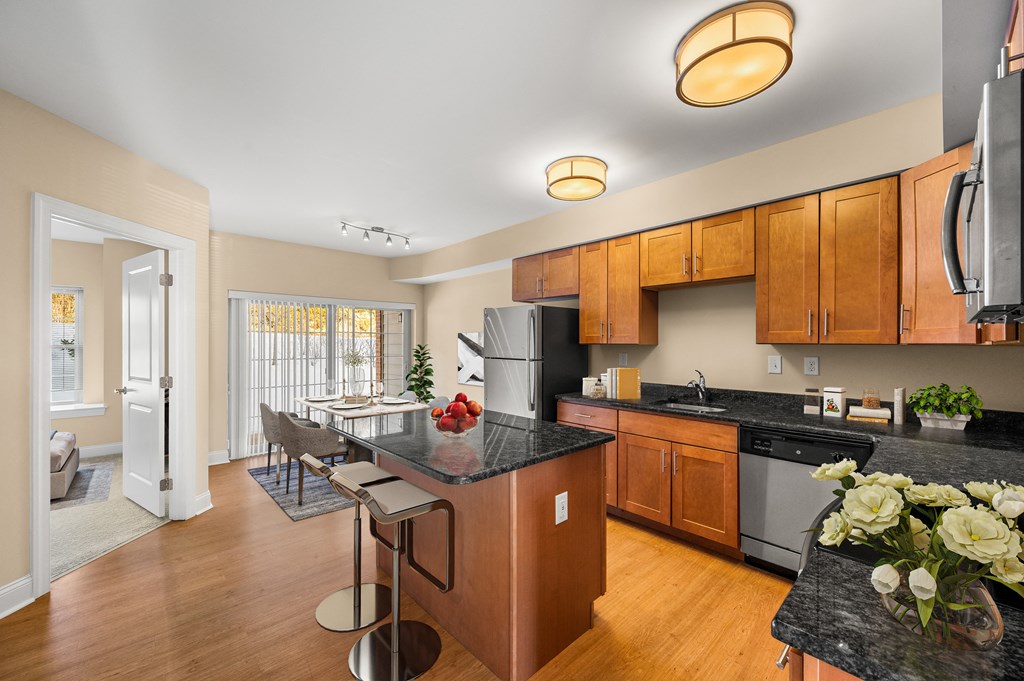 A kitchen with wooden cabinets and a black countertop.