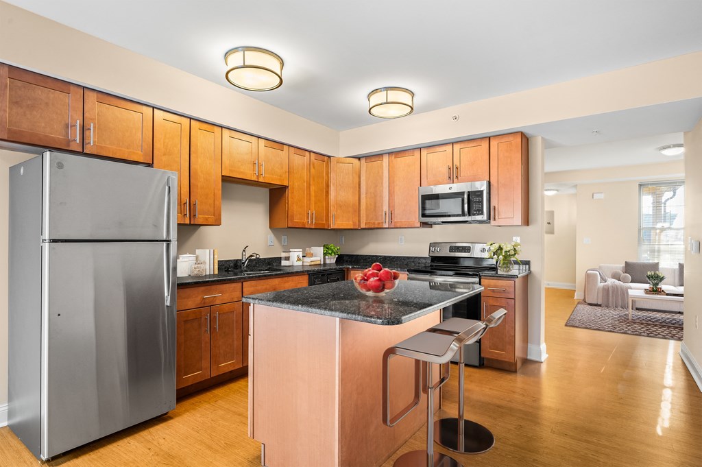 A kitchen with wooden cabinets and a black counter top.