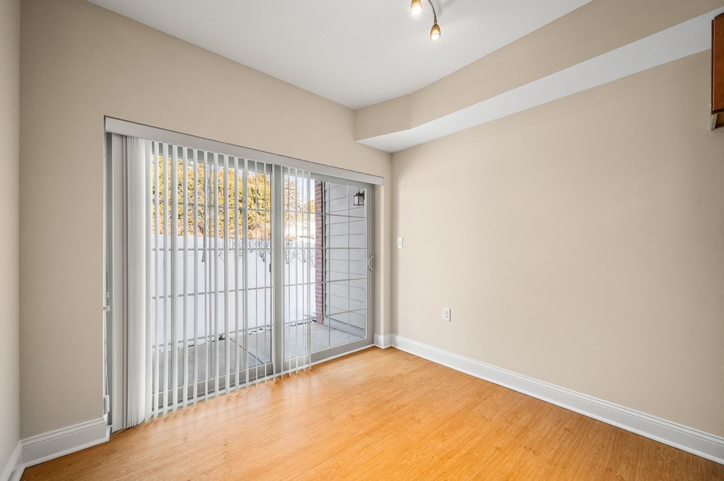 A room with a sliding door leading to a balcony.