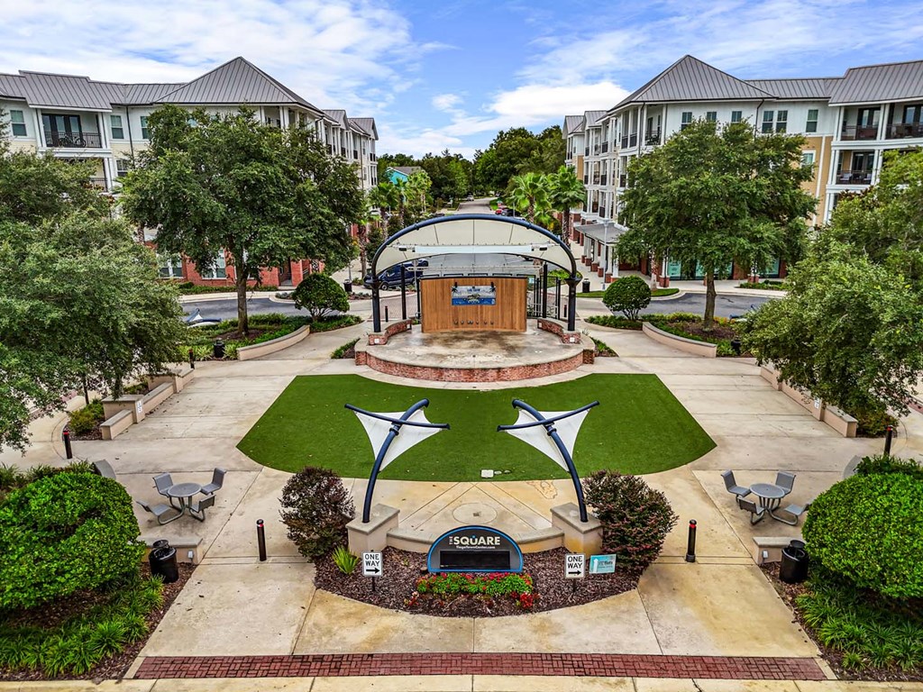 A large building with a glass dome is surrounded by trees and bushes.