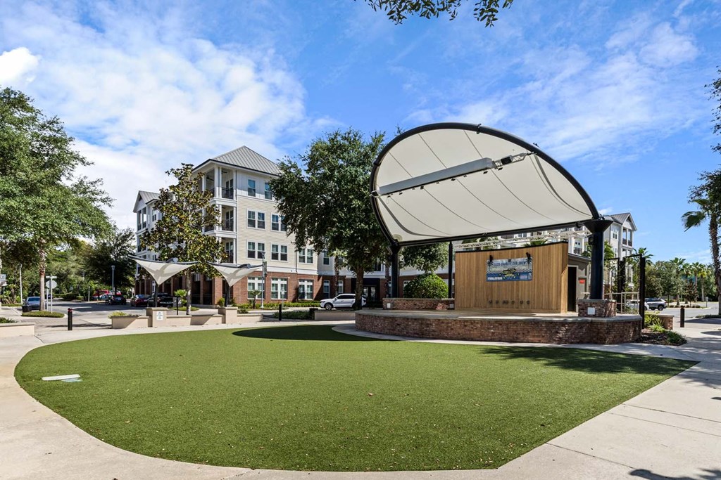 A large white satellite dish is on a building in a park.