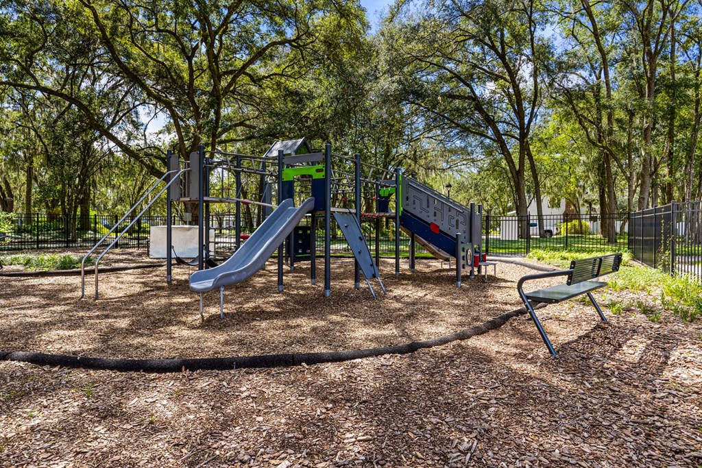 A playground with a slide and a bench.
