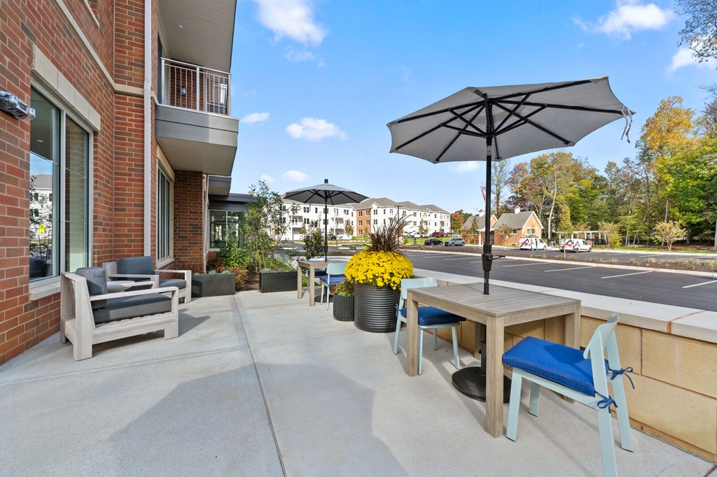 Our apartments feature spacious patios with tables, chairs, and umbrellas for outdoor relaxation at Hamilton at Eagleview, Exton, PA 19341