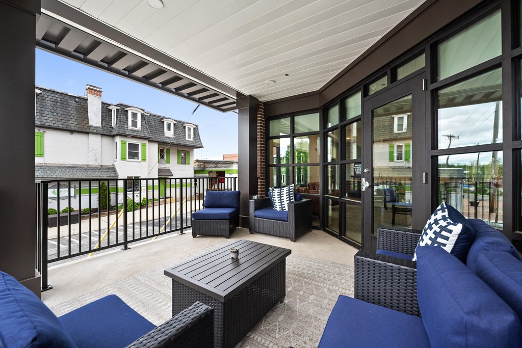 a covered patio with blue furniture and glass doors