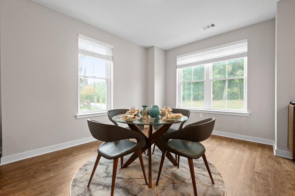 a dining room with a table and chairs and two windows at Hamilton at Eagleview, Exton Pennsylvania