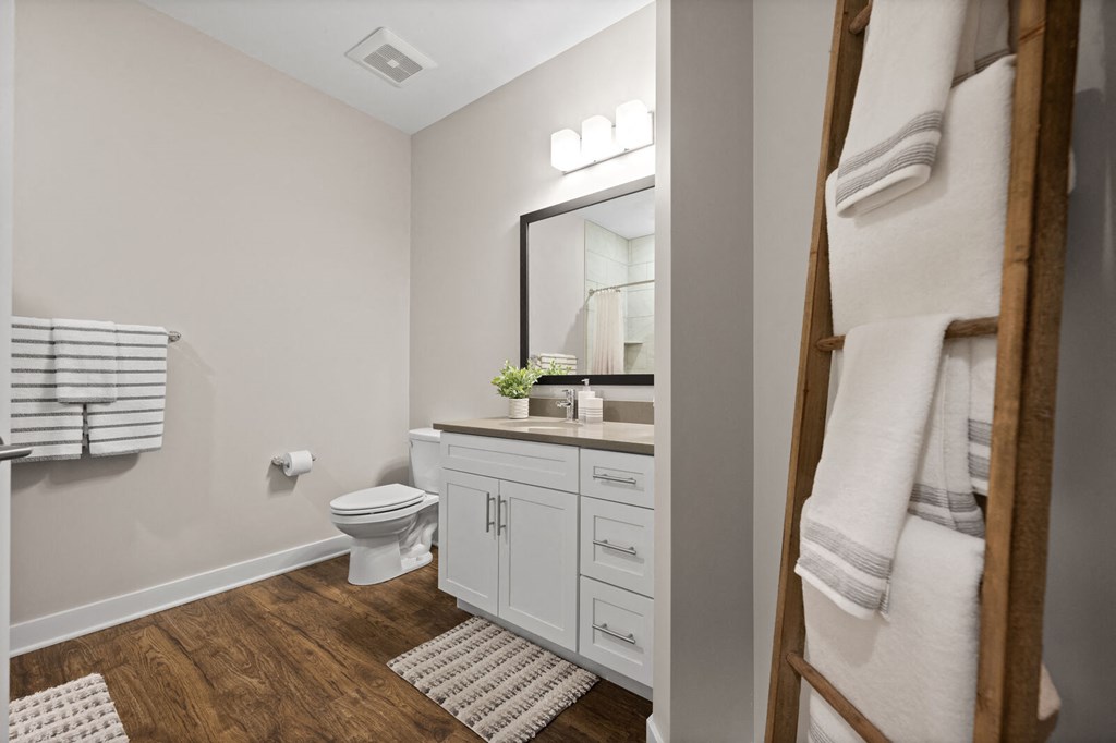 a bathroom with a toilet and a sink and a mirror at Hamilton at Eagleview, Exton