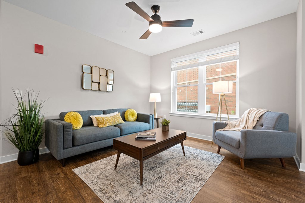 Bright living room featuring a cozy couch, a comfortable chair, and a ceiling fan at Hamilton at Eagleview, Exton, PA