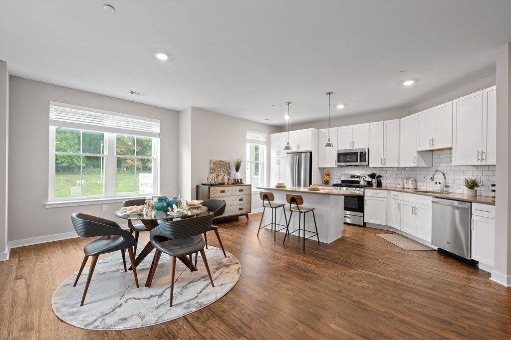 Open-concept kitchen with a central island, dining room table, and chairs at Hamilton at Eagleview in Exton, PA