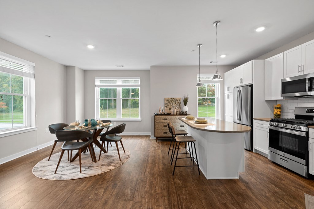 Modern kitchen with a central island and a dining table with chairs at Hamilton at Eagleview, Exton, PA 19341