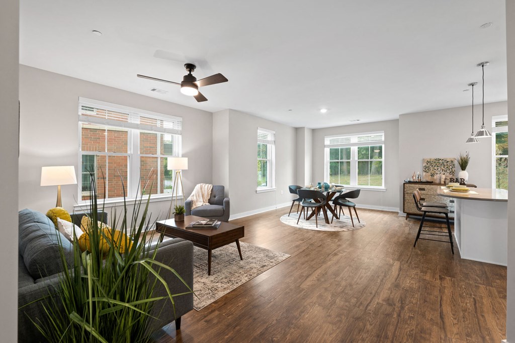 Spacious living room featuring a comfortable couch, a stylish table, and a ceiling fan at Hamilton at Eagleview in Exton, PA