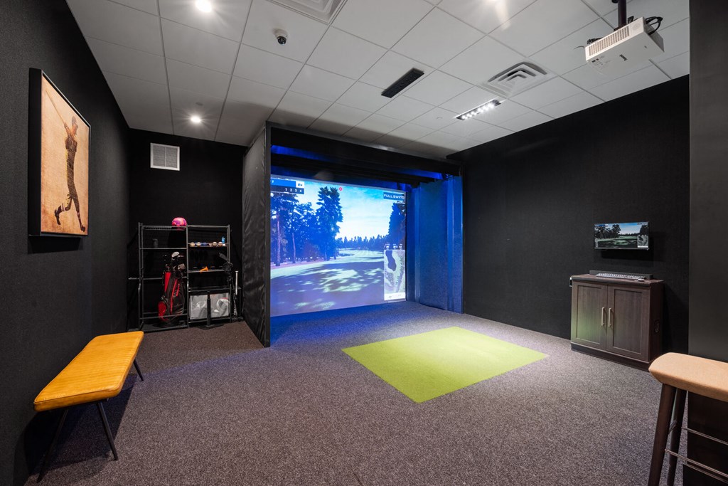A multi-sport simulator projector screen in a community room with sports equipment.
