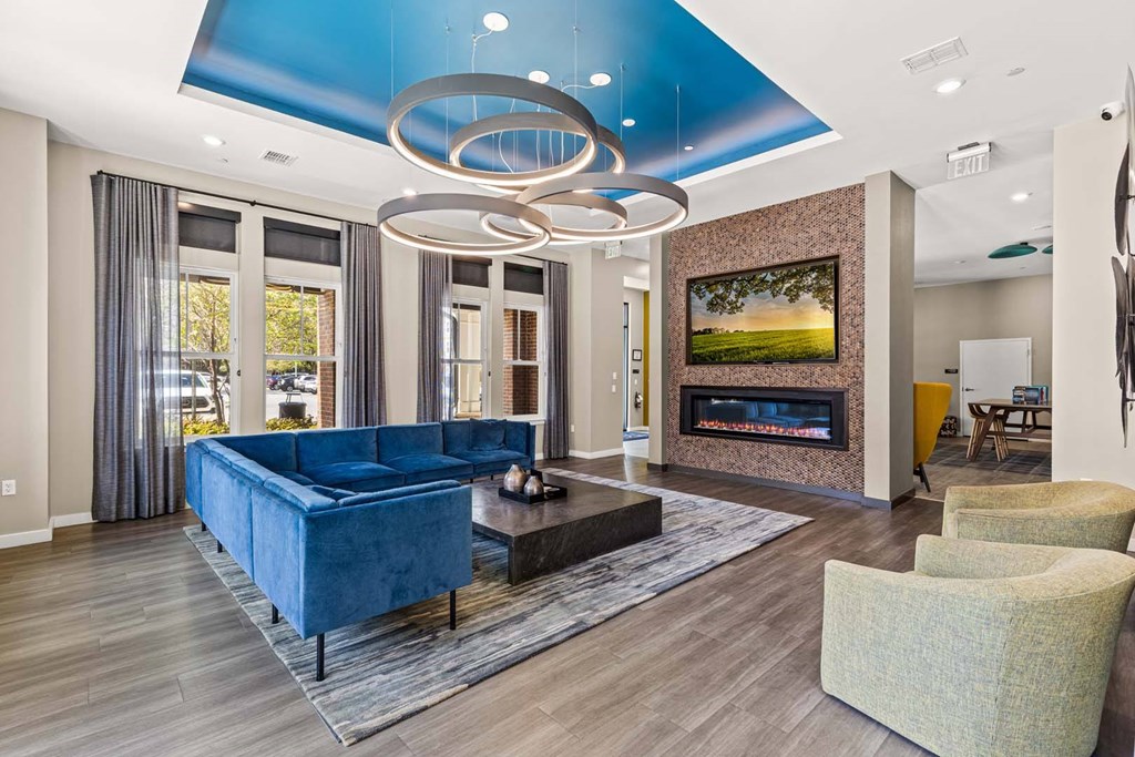 A modern living room with a blue couch and a fireplace.