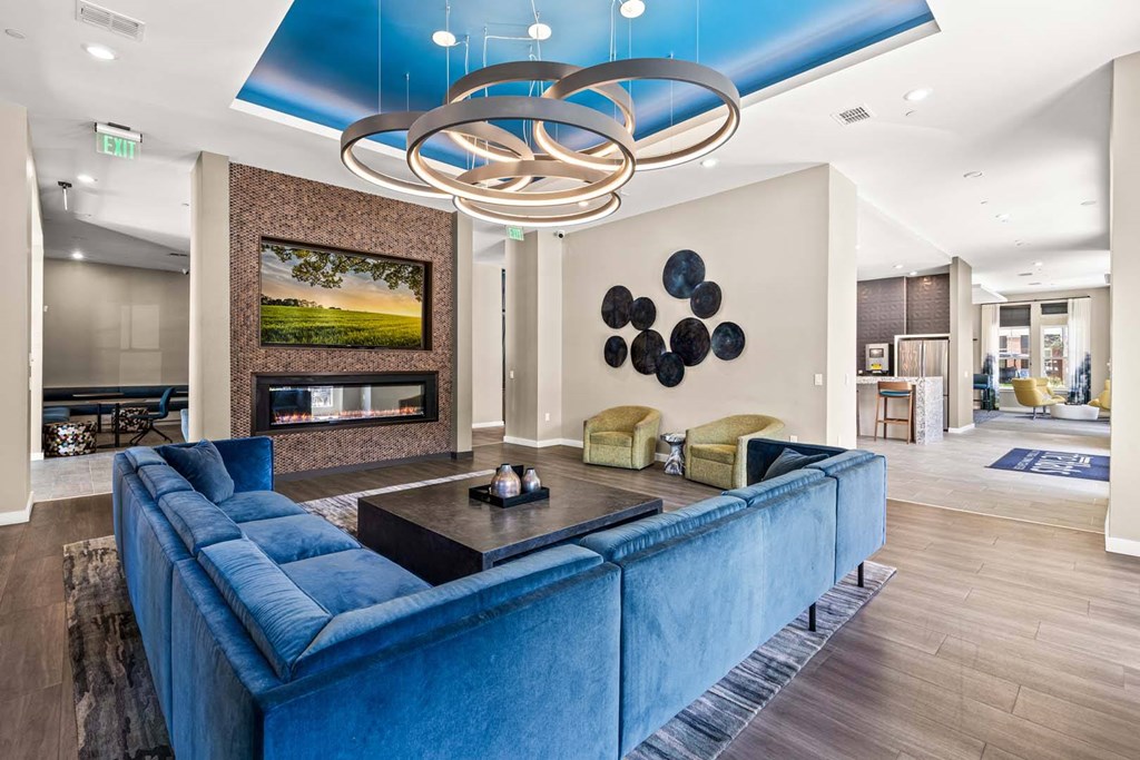 A modern living room with a blue couch and a fireplace.