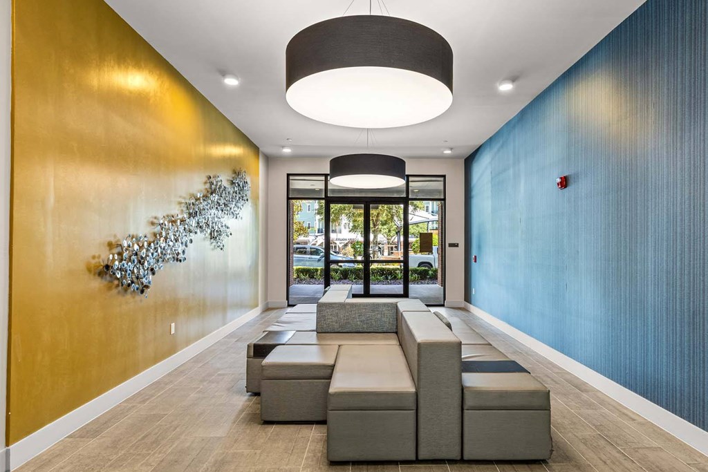 A long hallway with a bench and a wall hanging.