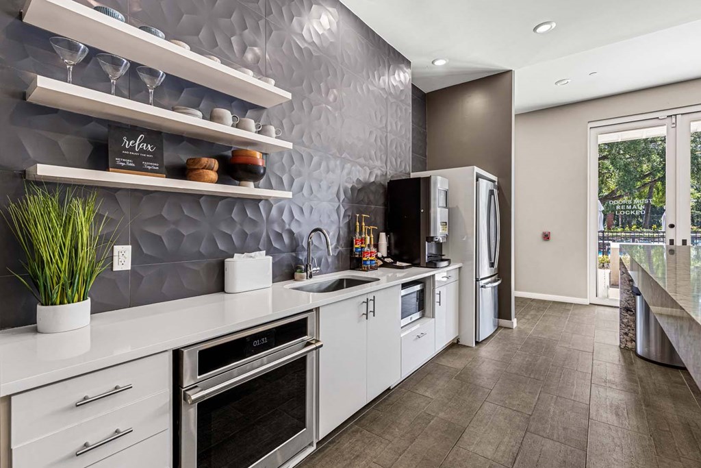 A modern kitchen with white appliances and a grey backsplash.