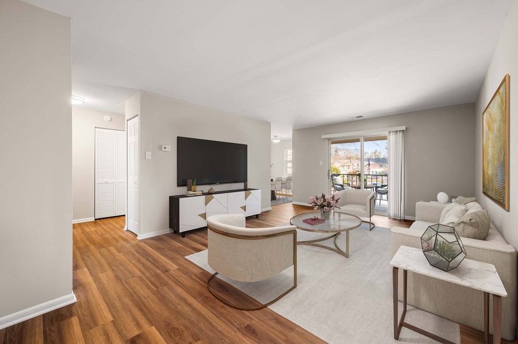 A living room with a white couch, a coffee table, and a television.