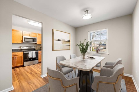 A dining room with a table and chairs.