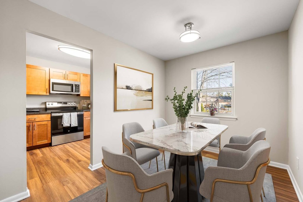 A dining room with a table and chairs.