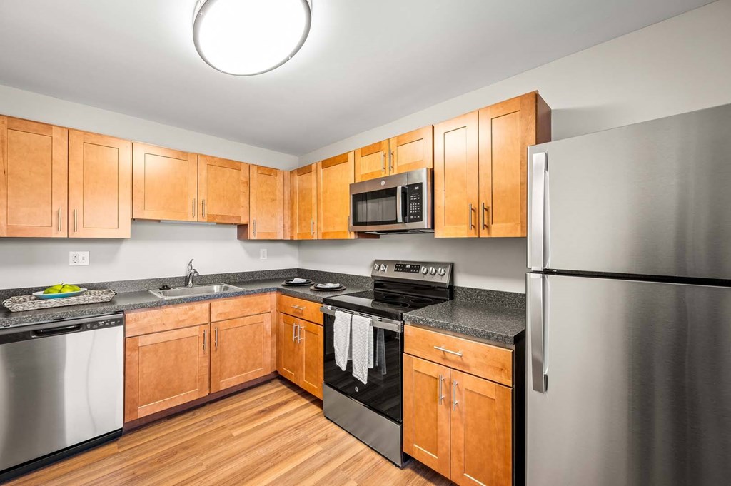 A kitchen with wooden cabinets and stainless steel appliances.